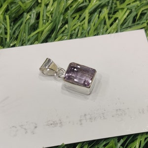 Könnte beinhalten: Ein silberner Anhänger mit einem rechteckigen Amethyst-Edelstein. Der Anhänger hat ein schlichtes Design und ist perfekt, um jedem Outfit einen Hauch von Eleganz zu verleihen.