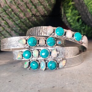Peut inclure: Quatre bracelets en argent avec des pierres turquoise et opales. Les bracelets sont empilés les uns sur les autres et ont une finition texturée.
