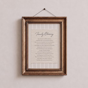 Könnte beinhalten: Ein gerahmtes Wandbild mit dem Text Family Blessing, gedruckt auf cremefarbenem Papier mit unebenen Kanten. Der Druck befindet sich vor einem hellbeigen, gestreiften Hintergrund in einem dunkelbraunen Holzrahmen mit einem Aufhängedraht.