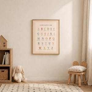 May include: A rectangular wall print featuring the alphabet in a serif font with the title GOD SAYS I AM at the top. Each letter is paired with a word in a muted color palette of blue, orange, and brown, set against a light beige checkered border.