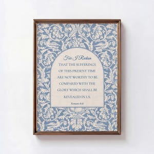 Puede incluir: Una impresión enmarcada con un fondo de patrón floral azul y blanco. La impresión presenta el texto "For I Reckon" y una cita de Romanos 8:18 en un panel arqueado de color crema. El marco es de color marrón oscuro.