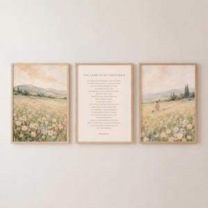 Puede incluir: Un tríptico de arte mural enmarcado que presenta dos pinturas de paisajes de un prado de flores silvestres con colinas bajo un cielo suave, flanqueando una impresión central que contiene el texto del Salmo 23 en una fuente serif.