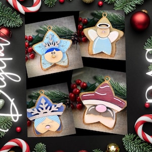 May include: Four wooden star-shaped ornaments with painted faces. The ornaments are painted in blue, red, and white with snowflake and angel wing details. The ornaments are perfect for decorating a Christmas tree.