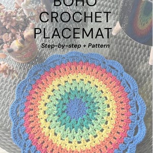 May include: A colorful, crocheted placemat with a rainbow design. The placemat features a blue scalloped edge and a central pattern of concentric circles in shades of blue, green, yellow, orange, and red. Text on the image reads "BOHO CROCHET PLACEMAT".