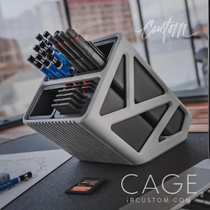 May include: A grey and black geometric desk organiser with multiple compartments for pens, pencils, and other office supplies. The organiser is labelled "CAGE" and "IRCUSTOM.COM".