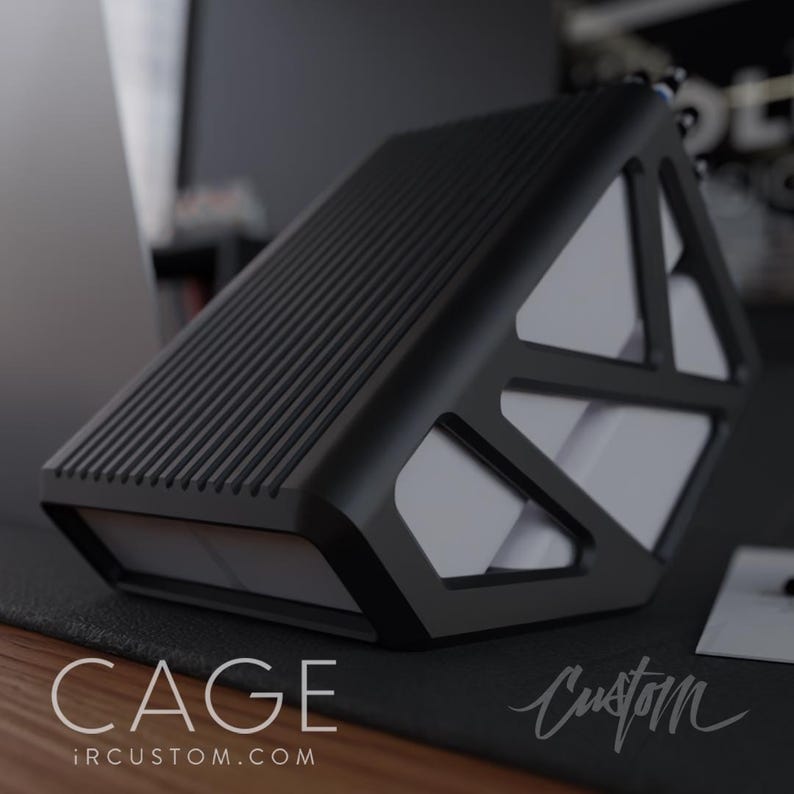 May include: Black hard drive case with a geometric design and a textured top. The case has the text "CAGE" and "iRCUSTOM.COM" printed on the bottom. The case is sitting on a black surface.