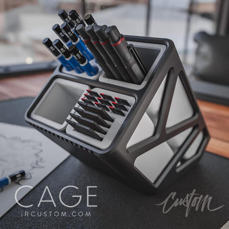 May include: A black and white desk organiser with multiple compartments for pens, pencils, and other office supplies. The organiser has a geometric design and the text "CAGE IRCUSTOM.COM" is printed on the bottom.
