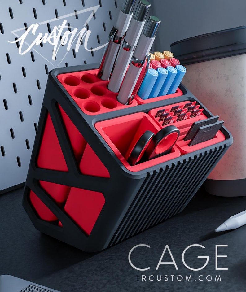 May include: A red and black geometric desktop organiser with multiple compartments for pens, pencils, and other office supplies. The organiser has a black and red striped pattern on the side. The text "CAGE ircustom.com" is printed on the bottom of the organiser.