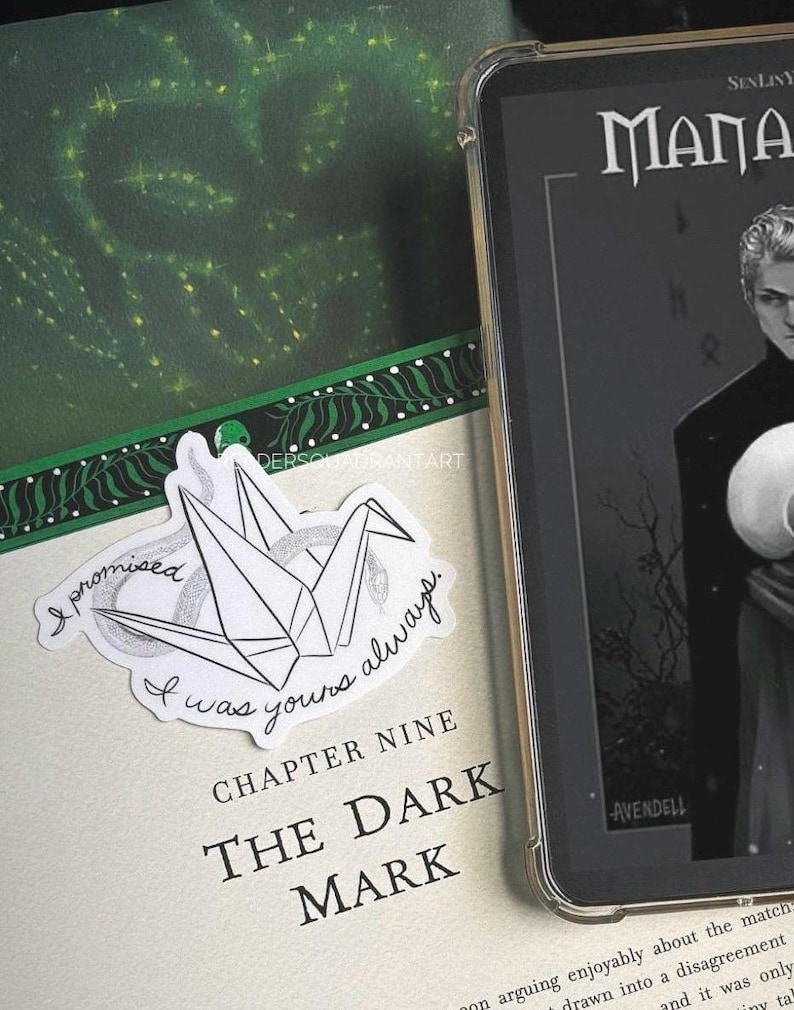 Puede incluir: Una gr&uacute;a de origami blanca con un dise&ntilde;o de serpiente blanco y negro. La gr&uacute;a est&aacute; sobre un libro con el texto "I promised I was yours always." y "Chapter Nine The Dark Mark".