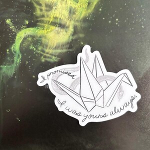 Puede incluir: Una pegatina blanca con una gr&uacute;a de origami en blanco y negro y el texto "I promised I was yours always".