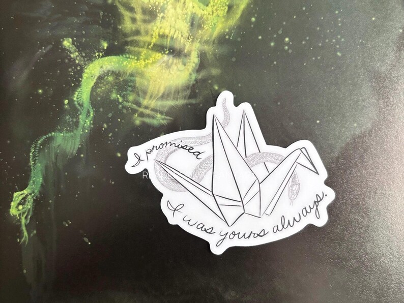 Puede incluir: Una pegatina blanca con una gr&uacute;a de origami en blanco y negro y el texto "I promised I was yours always".