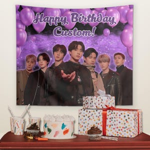 Puede incluir: Una pancarta de cumpleaños morada con el texto "Happy Birthday Custom!" y un grupo de siete personas. La pancarta está decorada con globos morados. Una mesa exhibe un pastel, cupcakes, regalos y vasos de fiesta.