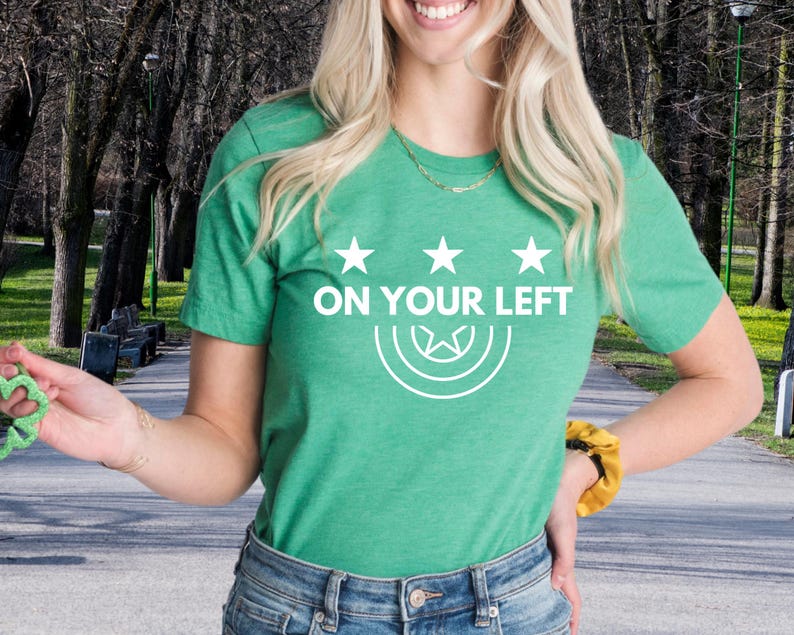 a woman wearing a green t - shirt that says on your left