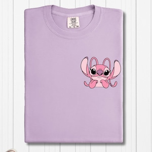 a purple t - shirt with a pink crab on it