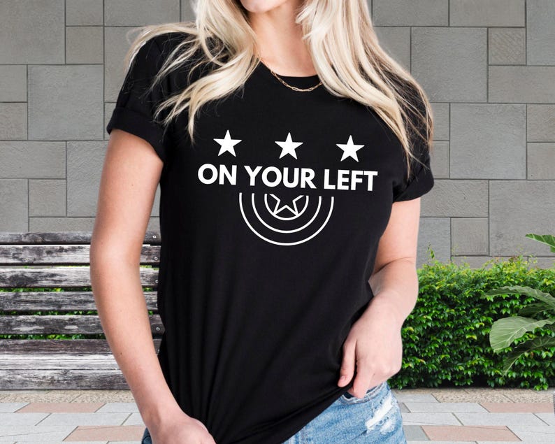 a woman wearing a black t - shirt that says on your left