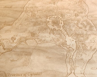 May include: A wood-burned map of the Province of Cyrodiil, a fictional region from the Elder Scrolls video game series. The map is labeled with various locations and features, including the Imperial City, the Nibenay River, and the Black Marsh.