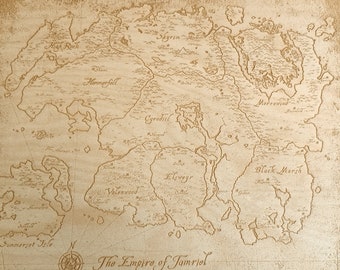 May include: A wooden map of the fictional continent of Tamriel from the Elder Scrolls video game series. The map is engraved with the names of the various provinces, including Skyrim, Morrowind, and Cyrodiil. The map is surrounded by a decorative border.