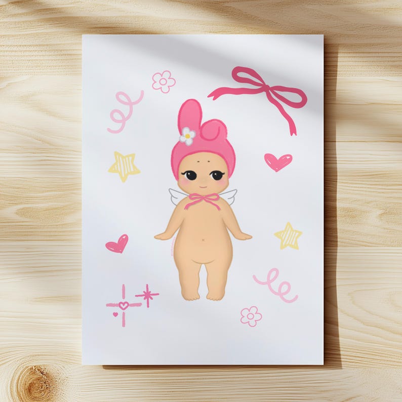 May include: A whimsical illustration of a cherubic figure with a pink hat and wings, adorned with pink bows, hearts, stars, and flowers. The artwork is set against a white background with a wooden texture.