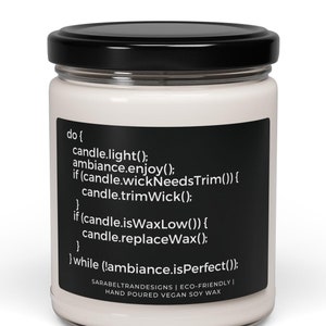 Peut inclure: Une bougie blanche avec une &eacute;tiquette noire qui indique "do { candle.light(); ambiance.enjoy(); if (candle.wickNeedsTrim()) { candle.trimWick(); } if (candle.isWaxLow()) { candle.replaceWax(); } } while (!ambiance.isPerfect());" et "SARAREITRANDESIGNS | ECO-FRIENDLY | HAND POURED VEGAN SOY WAX".