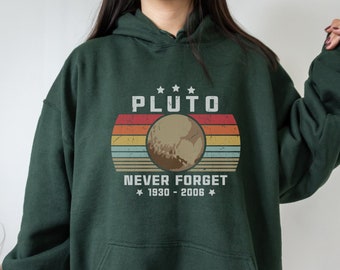 May include: A dark green hooded sweatshirt with a retro-style graphic of Pluto, the text "Pluto Never Forget 1930 - 2006", and three stars.