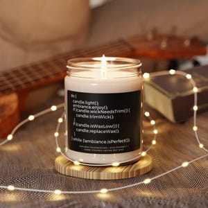 Peut inclure: Une bougie en cire de soja avec une &eacute;tiquette noire contenant du code. Le code indique "do { candle.light(); ambiance.enjoy(); if (candle.wickNeedsTrim()) { candle.trimWick(); if (candle.isWaxLow()) { candle.replaceWax(); while (!ambiance.isPerfect()); } SARARELYRANDESIGNS | ECO-FRIENDLY! HAND POURED VEGAN SOY WAX"