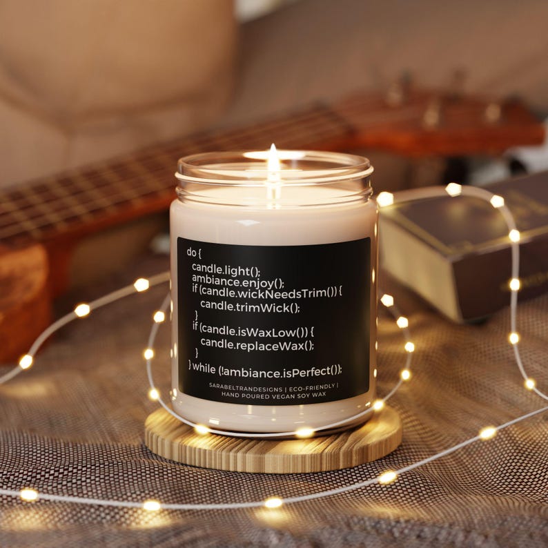 Peut inclure: Une bougie en cire de soja avec une &eacute;tiquette noire contenant du code. Le code indique "do { candle.light(); ambiance.enjoy(); if (candle.wickNeedsTrim()) { candle.trimWick(); if (candle.isWaxLow()) { candle.replaceWax(); while (!ambiance.isPerfect()); } SARARELYRANDESIGNS | ECO-FRIENDLY! HAND POURED VEGAN SOY WAX"