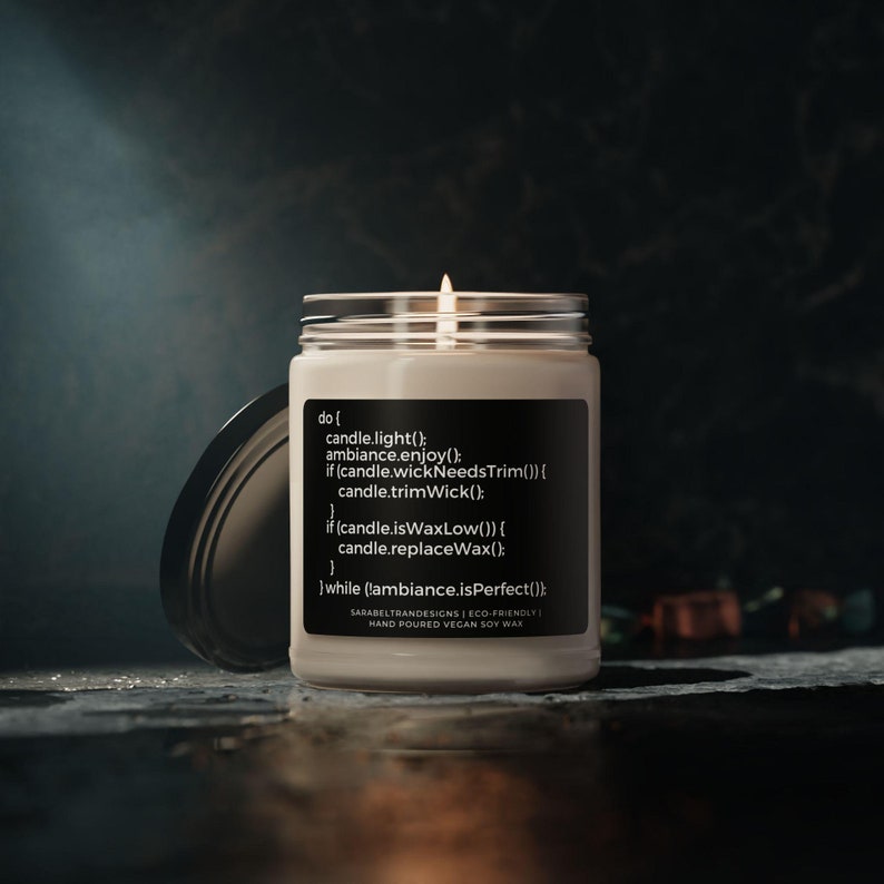 Peut inclure: Une bougie blanche avec une &eacute;tiquette noire qui indique "do { candle.light(); ambiance.enjoy(); if (candle.wickNeedsTrim()) { candle.trimWick(); } if (candle.isWaxLow()) { candle.replaceWax(); } while (lambiance.isPerfect()); } SARABELTRANDESIGNS | ECO-FRIENDLY HAND POURED VEGAN SOY WAX".