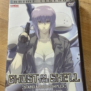 May include: Sealed DVD of "Ghost in the Shell: Stand Alone Complex Complete Collection." The cover features a female anime character with purple hair, holding a gun. The DVD case is in a plastic wrap.