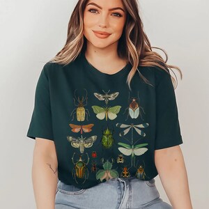 May include: A dark green t-shirt with a vintage illustration of various insects, including beetles, butterflies, and moths.