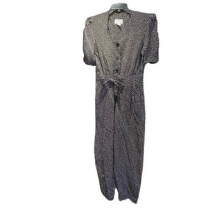 May include: A black and white polka dot jumpsuit with a button-up front and a tie at the waist.