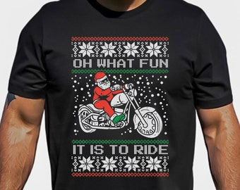 May include: Black t-shirt with a Christmas-themed design featuring Santa Claus riding a motorcycle. The text on the shirt reads "Oh What Fun It Is To Ride".