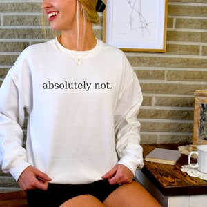 May include: White sweatshirt with the text "absolutely not." printed in black.