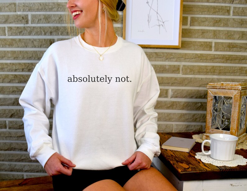 May include: White sweatshirt with the text "absolutely not." printed in black.