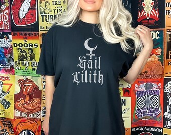 Puede incluir: Camiseta negra con un estampado plateado de una luna creciente, un pentagrama y el texto "Hail Lilith".