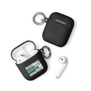 May include: Black AirPods case with a silver carabiner clip, one open with white AirPods inside, and a loose AirPod. The open case has a label with the text "Midazolam Injection, USP".