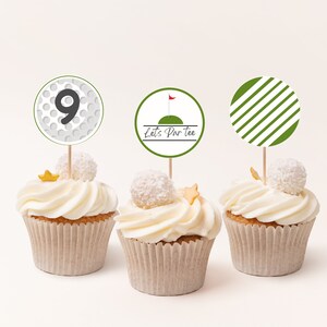 May include: Three white cupcakes with green and white golf-themed cupcake toppers. The toppers say "Let's Par Tee" and feature a golf ball with the number 9 and a golf flag.