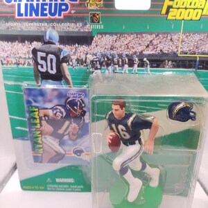 May include: A Starting Lineup 1999 Football 2000 collectible figure of Ryan Leaf in a Chargers uniform. The figure is in a clear plastic case with a miniature helmet. The packaging includes the text "Starting Lineup".