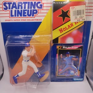 Puede incluir: Una figura de béisbol Starting Lineup de un jugador con uniforme blanco y azul, empaquetada con un póster y una tarjeta de intercambio de Nolan Ryan. El embalaje es azul y amarillo con el texto "Starting Lineup" y "Sports Super Star Collectibles".