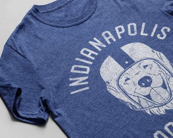 May include: A blue t-shirt featuring a white graphic of a dog wearing a football helmet and the text "Indianapolis Football".