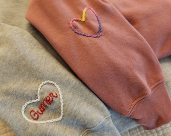 Fügen Sie einem Rundhals-Sweatshirt ein handgesticktes Design hinzu
