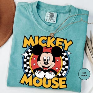 a mickey mouse t - shirt sitting on top of a table