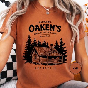 a woman sitting on a couch wearing an orange shirt