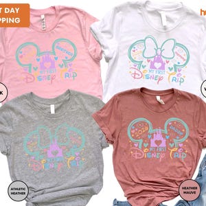 a collection of four Disney-themed t-shirts, each with a unique color and design. The t-shirts feature the iconic Mickey Mouse ears and the text "My first Disney trip" in a playful and colorful style.