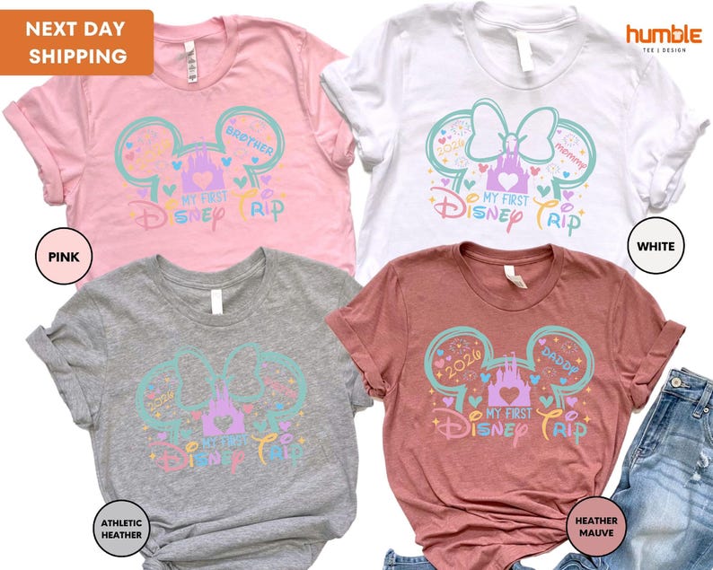 a collection of four Disney-themed t-shirts, each with a unique color and design. The t-shirts feature the iconic Mickey Mouse ears and the text "My first Disney trip" in a playful and colorful style.
