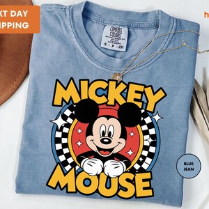 a mickey mouse t - shirt with a hat on top of it