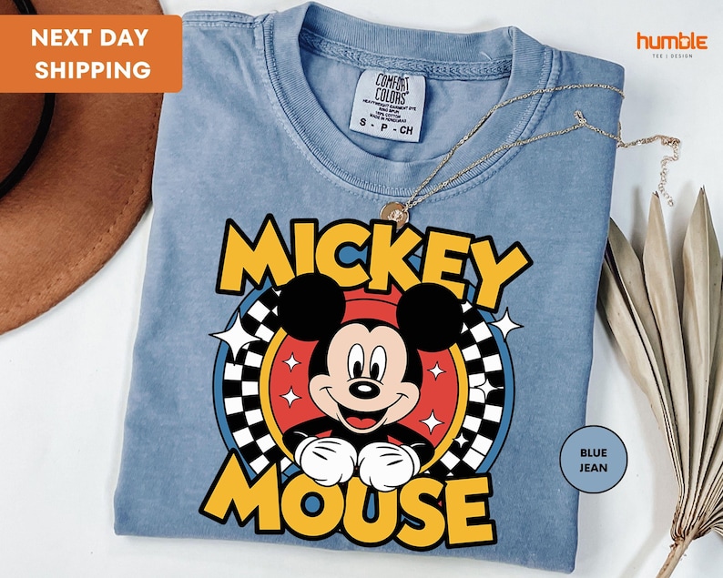 a mickey mouse t - shirt with a hat on top of it