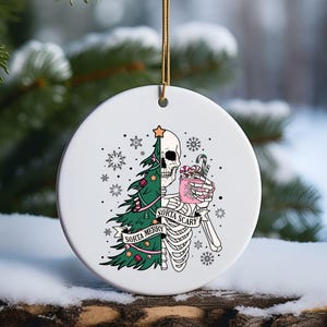 a ceramic ornament with a skeleton holding a christmas tree