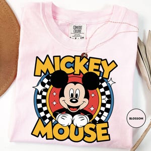 a pink shirt with mickey mouse on it