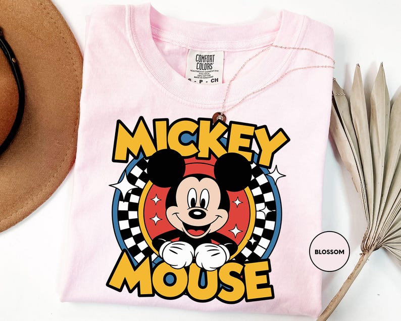 a pink shirt with mickey mouse on it
