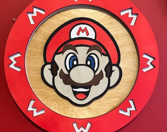 May include: A red circular wooden sign with a white outline and the letter "M" repeated around the edge. The center of the sign features a cartoon image of Mario, the video game character, with a red hat and mustache.